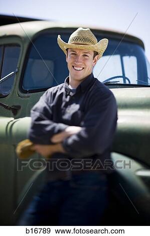 Man in cowboy hat leaning on truck smiling View Large Photo Image Stock Photo - Man in cowboy hat leaning on truck smiling. Fotosearch