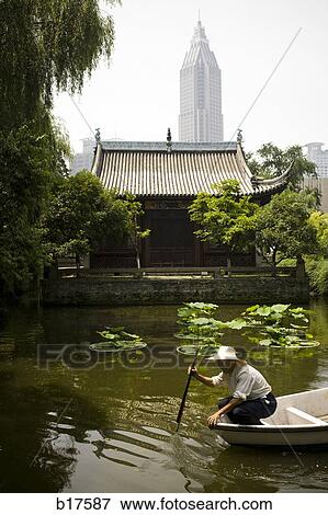 Man in fishing boat on water with city skyline in background View Large Photo Image Stock Photo - Man in fishing boat on water with city skyline in background. Fotosearch