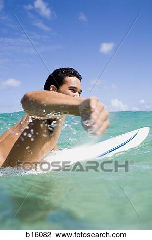 Man in water with surfboard View Large Photo Image Stock Image - Man in water with surfboard. Fotosearch