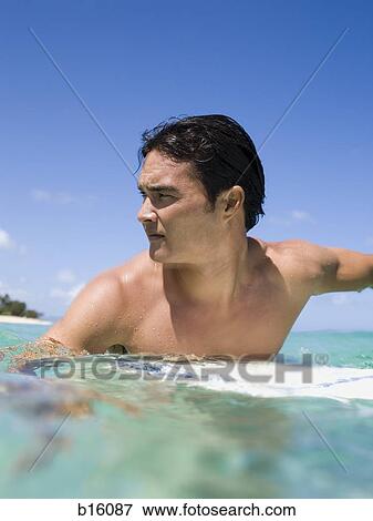 Man in water with surfboard View Large Photo Image Stock Photo - Man in water with surfboard. Fotosearch