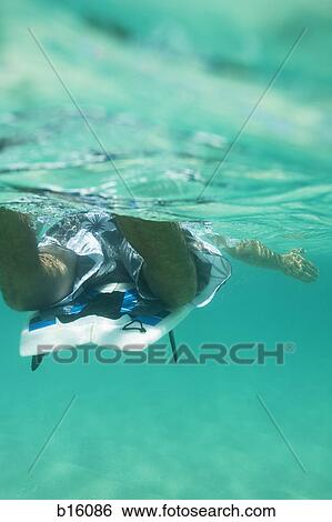 Stock Photograph - Man in water with surfboard. Fotosearch