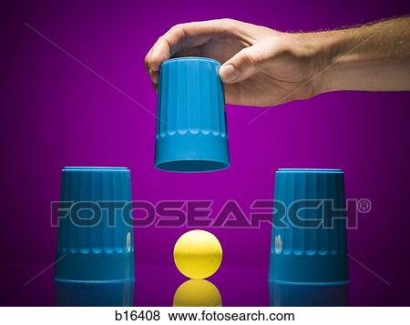 Man lifting cup to reveal ball View Large Photo Image Stock Photo - Man lifting cup to reveal ball. Fotosearch