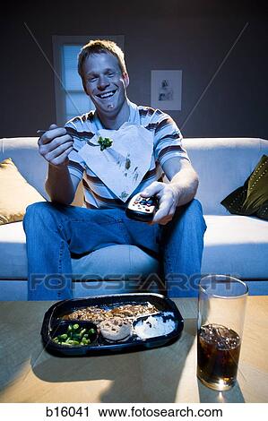 Man on sofa with frozen dinner and napkin with food smiling View Large Photo Image Stock Image - Man on sofa with frozen dinner and napkin with food smiling. Fotosearch