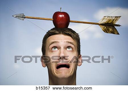 Man outdoors with arrow through red apple on head View Large Photo Image Stock Photo - Man outdoors with arrow through red apple on head. Fotosearch