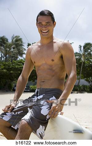 Man sitting on surfboard on beach smiling View Large Photo Image Stock Image - Man sitting on surfboard on beach smiling. Fotosearch