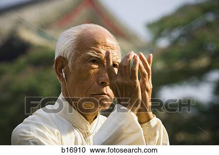 Man standing outdoors doing Kung Fu with ear buds View Large Photo Image Stock Image - Man standing outdoors doing Kung Fu with ear buds. Fotosearch
