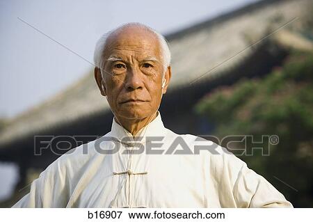 Man standing outdoors with ear buds and pagoda in background View Large Photo Image Stock Photo - Man standing outdoors with ear buds and pagoda in background. Fotosearch