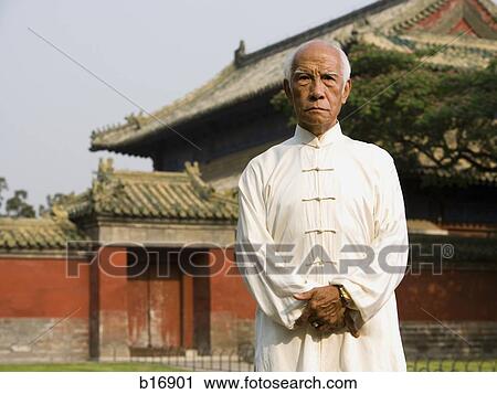 Man standing outdoors with pagoda in background View Large Photo Image Stock Image - Man standing outdoors with pagoda in background. Fotosearch