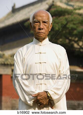 Man standing outdoors with pagoda in background View Large Photo Image Stock Image - Man standing outdoors with pagoda in background. Fotosearch