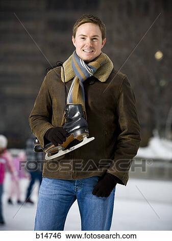 Man standing outdoors with skates View Large Photo Image Stock Photograph - Man standing outdoors with skates. Fotosearch