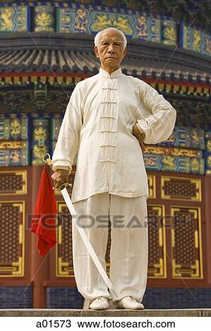 Man standing outdoors with sword View Large Photo Image Stock Image - Man standing outdoors with sword. Fotosearch