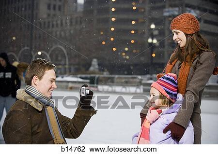 Man taking picture of woman and girl outdoors in winter View Large Photo Image Stock Image - Man taking picture of woman and girl outdoors in winter. Fotosearch