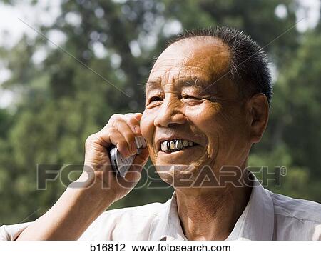 Man talking on cell phone outdoors smiling View Large Photo Image Stock Image - Man talking on cell phone outdoors smiling. Fotosearch
