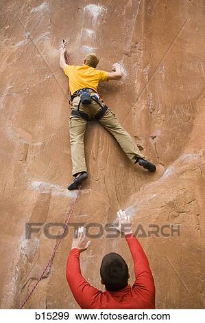 Man with arms raised and man climbing mountain View Large Photo Image Stock Photo - Man with arms raised and man climbing mountain. Fotosearch