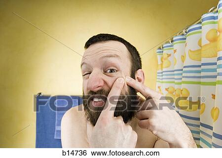 Man with beard in bathroom squeezing face View Large Photo Image Stock Photograph - Man with beard in bathroom squeezing face. Fotosearch