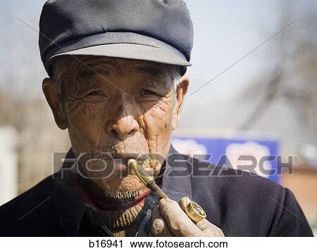 Man with cap smoking pipe outdoors View Large Photo Image Stock Image - Man with cap smoking pipe outdoors. Fotosearch