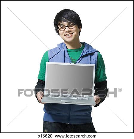 Man with eyeglasses holding laptop to camera smiling View Large Photo Image Stock Image - Man with eyeglasses holding laptop to camera smiling. Fotosearch