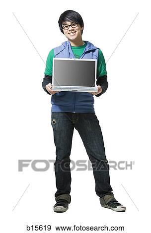 Stock Photo - Man with eyeglasses holding laptop to camera smiling. Fotosearch