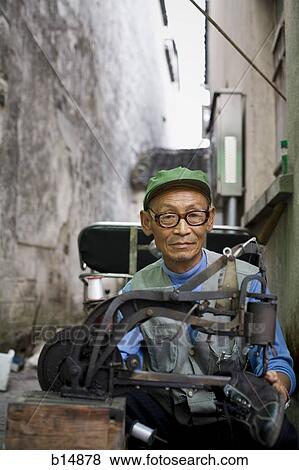 Stock Photo - Man with eyeglasses outdoor with shoe machine. Fotosearch