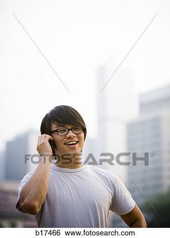 Man with eyeglasses talking on cell phone outdoors smiling View Large Photo Image Stock Photograph - Man with eyeglasses talking on cell phone outdoors smiling. Fotosearch
