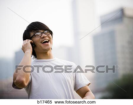 Man with eyeglasses talking on cell phone outdoors smiling View Large Photo Image Stock Photography - Man with eyeglasses talking on cell phone outdoors smiling. Fotosearch