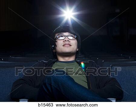 Man with eyeglasses watching film at movie theater View Large Photo Image Stock Image - Man with eyeglasses watching film at movie theater. Fotosearch