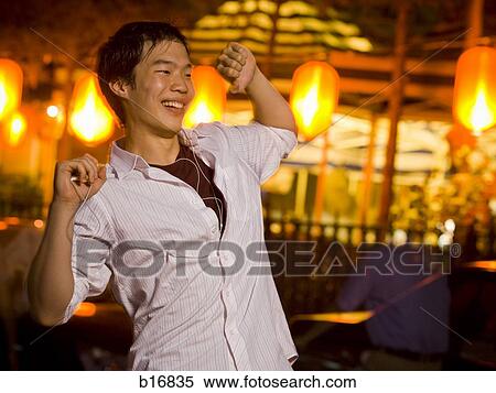 Stock Photography - Man with mp3 player dancing and smiling outdoors. Fotosearch