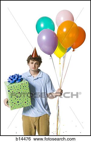 Man with party hat holding balloons and gift box looking sad View Large Photo Image Stock Photograph - Man with party hat holding balloons and gift box looking sad. Fotosearch