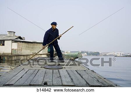Man with pole standing on dock outdoors View Large Photo Image Stock Image - Man with pole standing on dock outdoors. Fotosearch