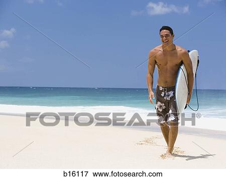 Stock Photo - Man with surfboard on beach smiling. Fotosearch