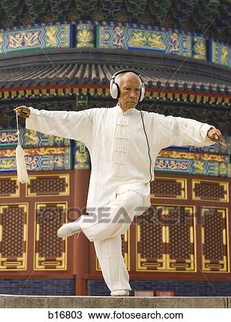 Man with sword doing Kung Fu with headphones View Large Photo Image Stock Image - Man with sword doing Kung Fu with headphones. Fotosearch