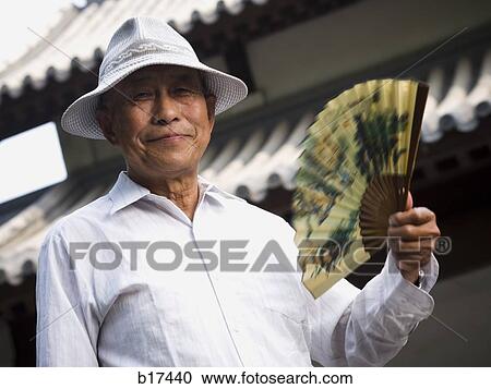 Mature man holding fan and smiling with motion blur View Large Photo Image Stock Image - Mature man holding fan and smiling with motion blur. Fotosearch
