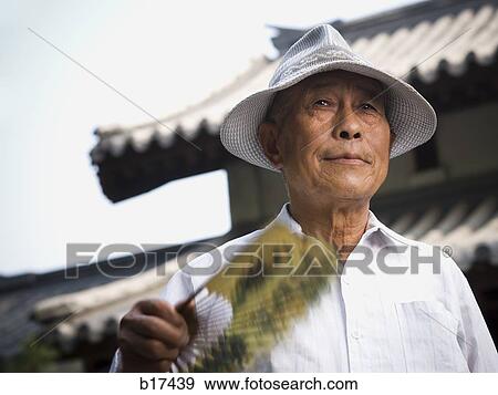 Mature man holding fan View Large Photo Image Stock Photo - Mature man holding fan. Fotosearch