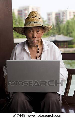 Mature man with straw hat and laptop outdoors View Large Photo Image Stock Photo - Mature man with straw hat and laptop outdoors. Fotosearch