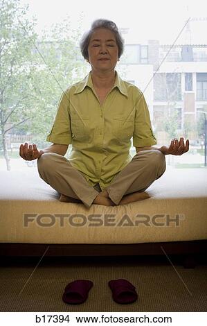 Mature woman sitting cross legged in meditation View Large Photo Image Picture - Mature woman sitting cross legged in meditation. Fotosearch