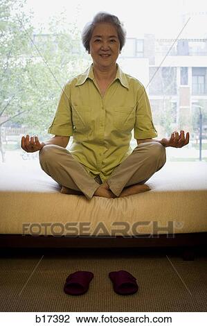 Mature woman sitting cross legged in meditation smiling View Large Photo Image Stock Image - Mature woman sitting cross legged in meditation smiling. Fotosearch