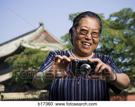 Mature woman with camera outdoors smiling View Large Photo Image Stock Image - Mature woman with camera outdoors smiling. Fotosearch