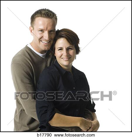 Mid adult couple standing with his arms around her. View Large Photo Image Stock Image - Mid adult couple standing with his arms around her.. Fotosearch