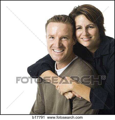 Mid adult couple standing with his arms around her. View Large Photo Image Stock Image - Mid adult couple standing with his arms around her.. Fotosearch