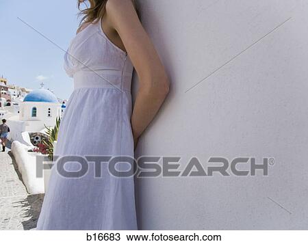 Mid section of woman leaning on wall outdoors by village View Large Photo Image Stock Image - Mid section of woman leaning on wall outdoors by village. Fotosearch