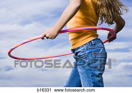 Mid section view of girl with hula hoop outdoors with clouds View Large Photo Image Stock Image - Mid section view of girl with hula hoop outdoors with clouds. Fotosearch
