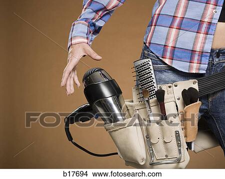 Mid section view of hairdresser with tool belt View Large Photo Image Picture - Mid section view of hairdresser with tool belt. Fotosearch
