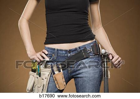 Mid section view of woman with tool belt View Large Photo Image Stock Image - Mid section view of woman with tool belt. Fotosearch