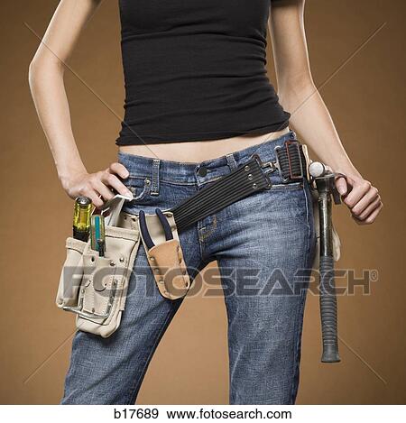 Mid section view of woman with tool belt View Large Photo Image Stock Photo - Mid section view of woman with tool belt. Fotosearch