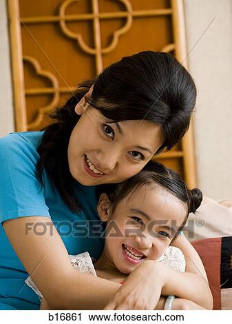 Mother and daughter embracing and smiling View Large Photo Image Stock Image - Mother and daughter embracing and smiling. Fotosearch