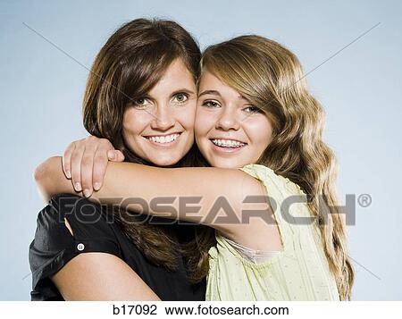 Stock Image - Mother and daughter embracing and smiling. Fotosearch