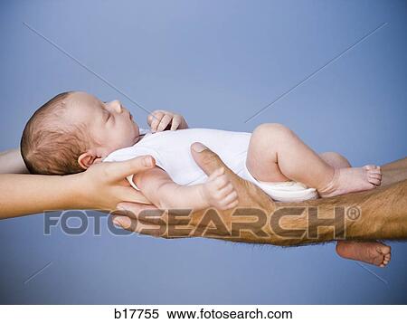 Stock Photography - Mother and Father holding Newborn baby.. Fotosearch