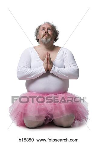 Stock Image - Obese man in tutu kneeling and praying. Fotosearch