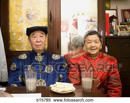 Older couple sitting at table with food and beverages View Large Photo Image Stock Photography - Older couple sitting at table with food and beverages. Fotosearch