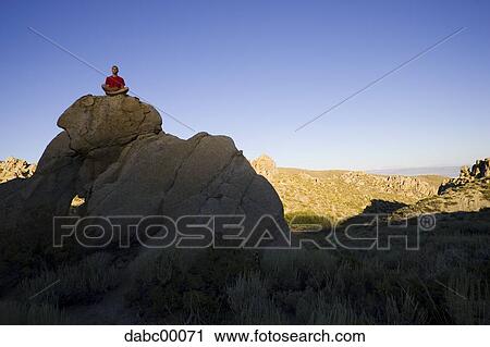 Person sitting on large rock outdoors doing yoga View Large Photo Image Stock Image - Person sitting on large rock outdoors doing yoga. Fotosearch